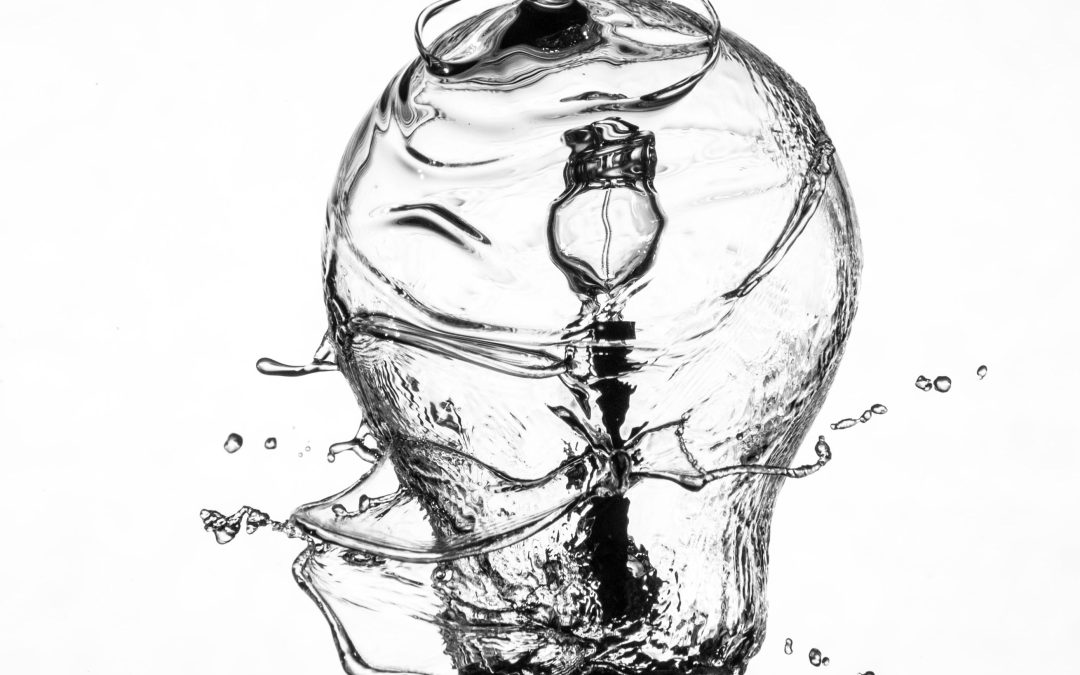 water flowing down onto a lightbulb whose inner filaments are liquifying from the change and throwing off droplets, black and white